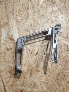 Wspornik, mocowanie podstopnicy  lewy, srebrny SUPPORT-FOOTREST MACH LH TSLV 5143787-402